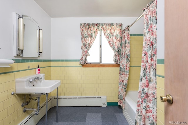 full bath featuring a baseboard radiator, a sink, tile walls, wainscoting, and shower / bath combo with shower curtain