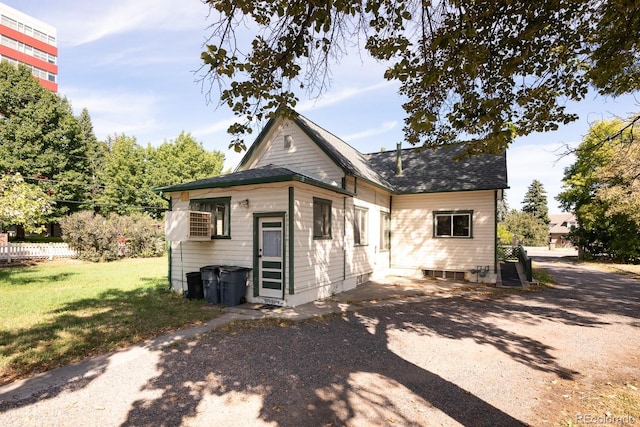 rear view of house featuring a lawn