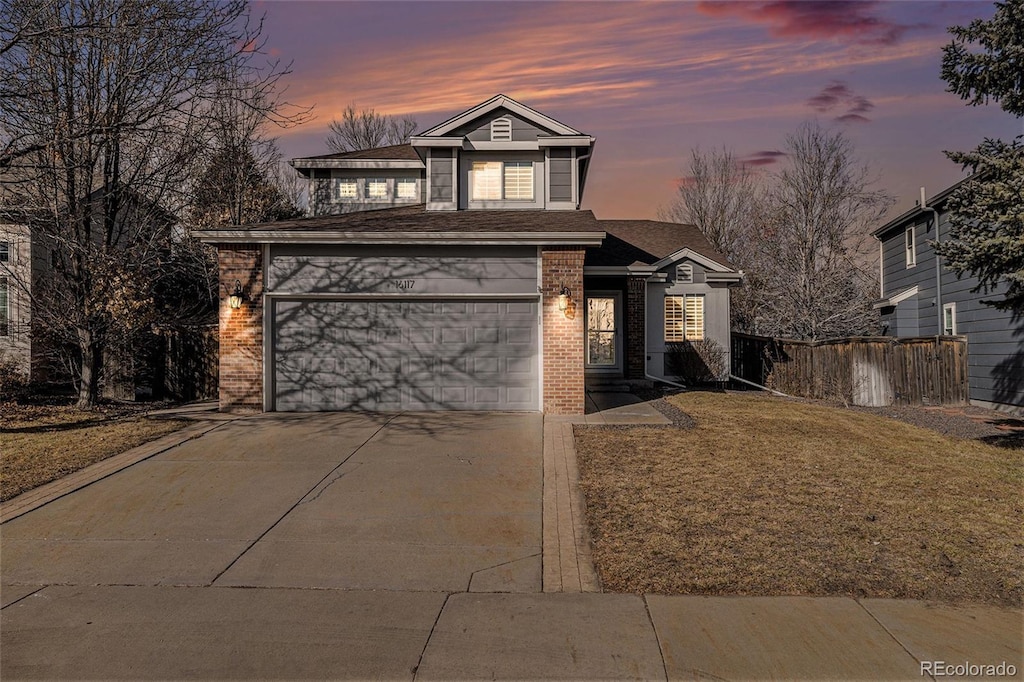 view of front of house featuring a garage and a lawn