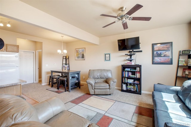 living room with ceiling fan with notable chandelier, light colored carpet, and beamed ceiling