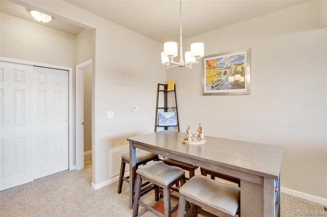 dining room with light carpet and an inviting chandelier