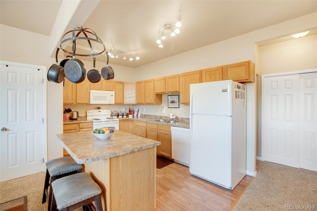 kitchen featuring sink, white appliances, light brown cabinets, and light wood-type flooring