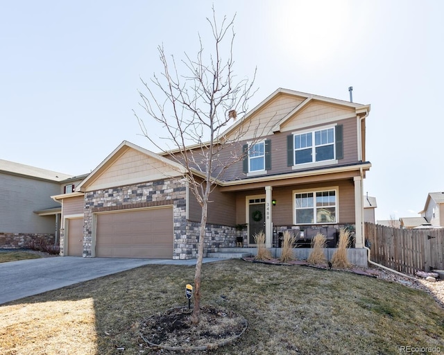 craftsman house with concrete driveway, stone siding, an attached garage, fence, and a porch