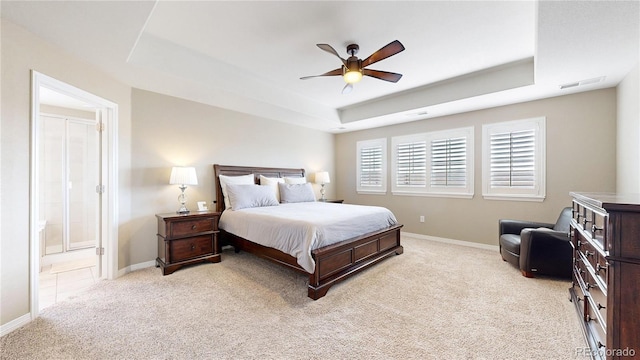 carpeted bedroom with a tray ceiling and ceiling fan