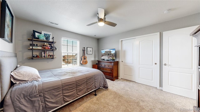 bedroom featuring ceiling fan, light colored carpet, and a closet