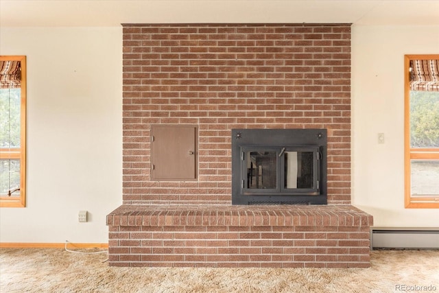 details featuring a baseboard heating unit, carpet floors, and a fireplace