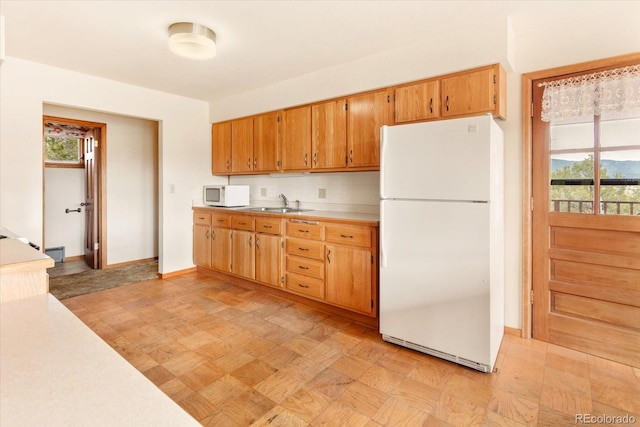 kitchen with sink, white appliances, and plenty of natural light