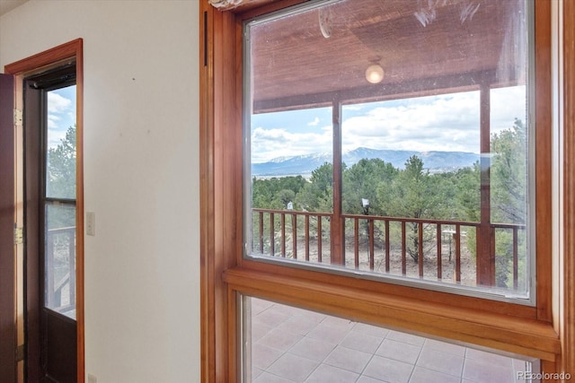 doorway with a mountain view and tile floors