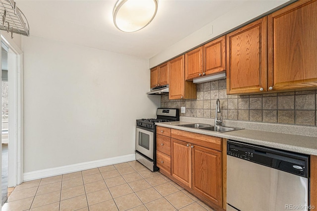 1355 Rosemary St, Denver, CO 80220 - kitchen with appliances with stainless steel finishes, a sink, backsplash, light tile patterned floors, and light countertops