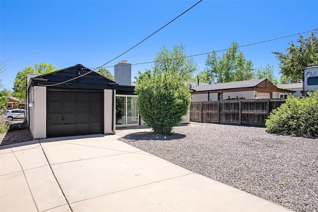 1355 Rosemary St, Denver, CO 80220 - view of front of home featuring concrete driveway, an attached garage, a chimney, and stucco siding