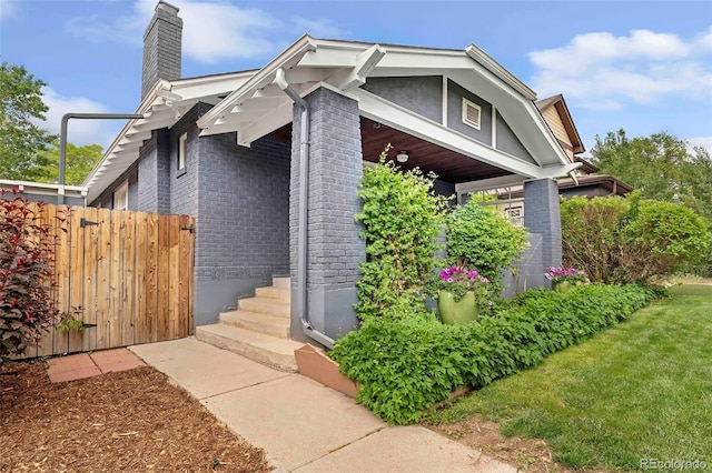 3341 Newton St, Denver, CO 80211 - view of front of home with brick siding, a chimney, and fence