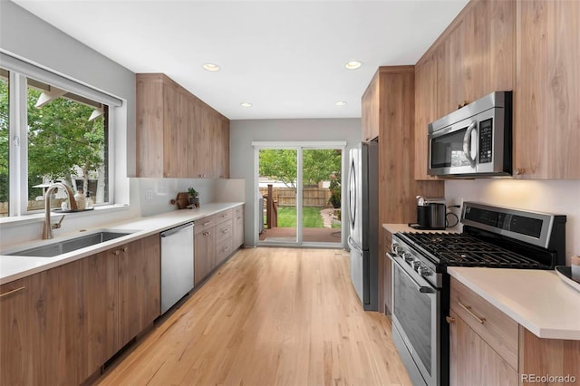 3341 Newton St, Denver, CO 80211 - kitchen featuring appliances with stainless steel finishes, a sink, light wood-type flooring, light countertops, and recessed lighting