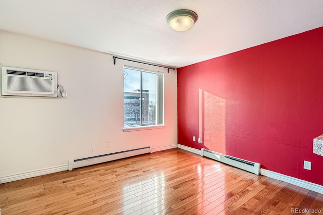 empty room with baseboard heating, light wood-type flooring, and a wall mounted AC