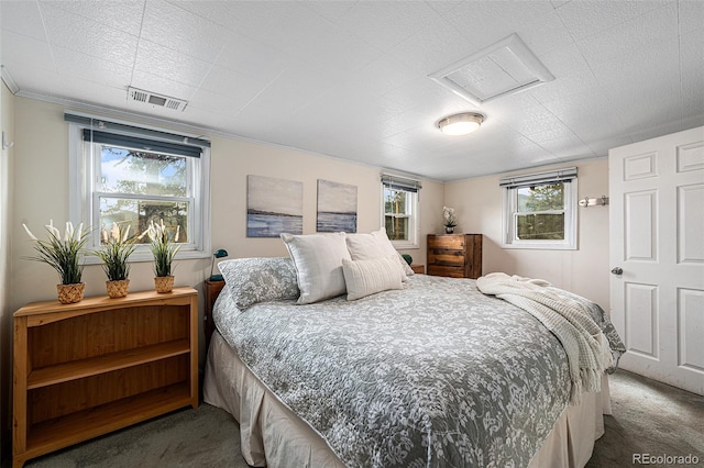 bedroom with attic access, visible vents, and carpet floors