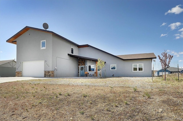 146 Raven Way, Buena Vista, CO 81211 - back of property featuring stone siding, a garage, stucco siding, and driveway