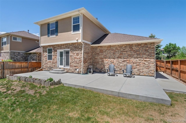 24738 E Layton Pl, Aurora, CO 80016 - back of property featuring stone siding, a patio, a shingled roof, and entry steps