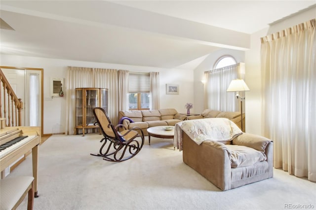 living room featuring lofted ceiling with beams and light carpet