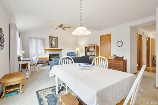 dining room featuring ceiling fan, vaulted ceiling, and light colored carpet