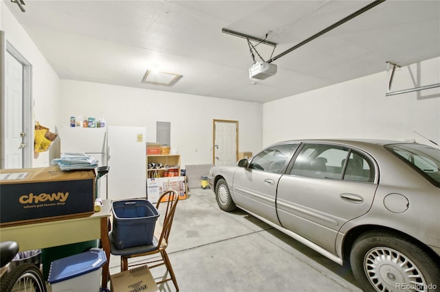 garage featuring white refrigerator and a garage door opener