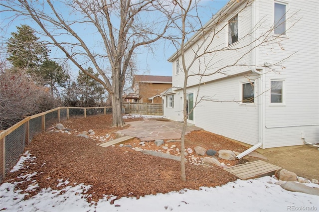 yard layered in snow with a patio area