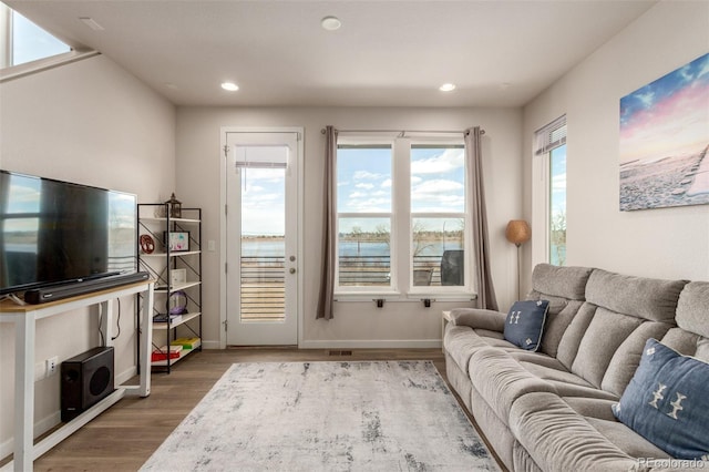 living area with visible vents, baseboards, wood finished floors, and recessed lighting