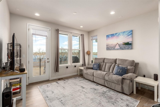 living area featuring baseboards, wood finished floors, visible vents, and recessed lighting