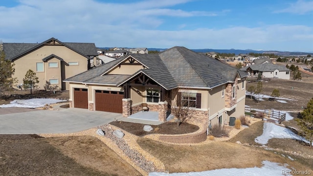 view of front of property with stucco siding, stone siding, concrete driveway, and an attached garage