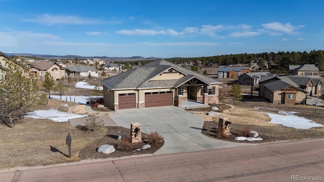 view of front facade featuring concrete driveway, stone siding, a garage, and a residential view