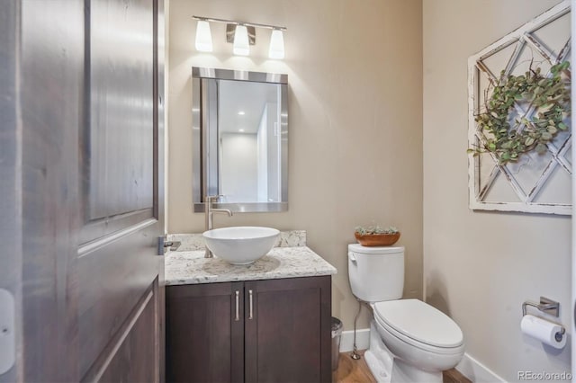 bathroom featuring vanity, toilet, and baseboards