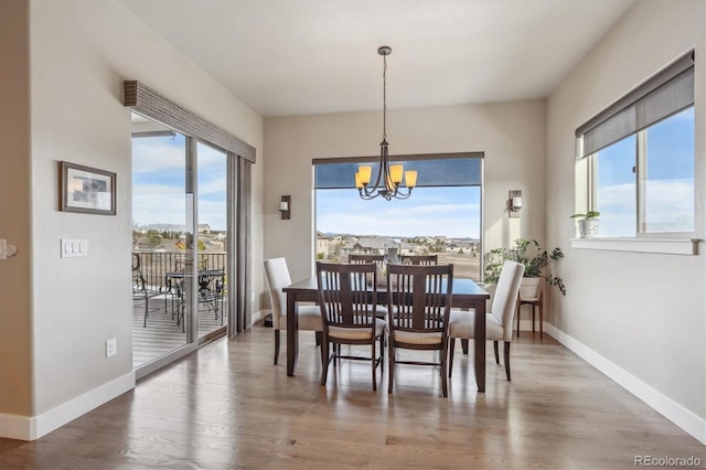 dining room featuring baseboards, an inviting chandelier, and wood finished floors