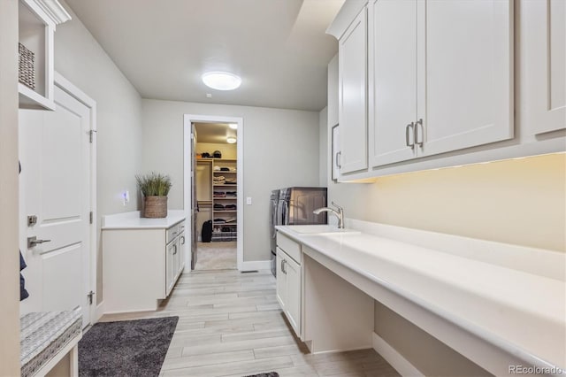 washroom with a sink, baseboards, and wood finish floors