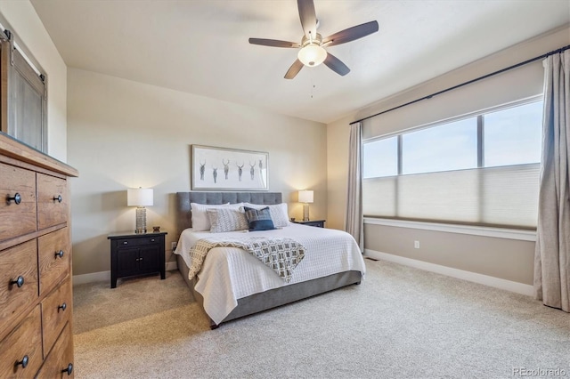 bedroom with light colored carpet, a ceiling fan, and baseboards