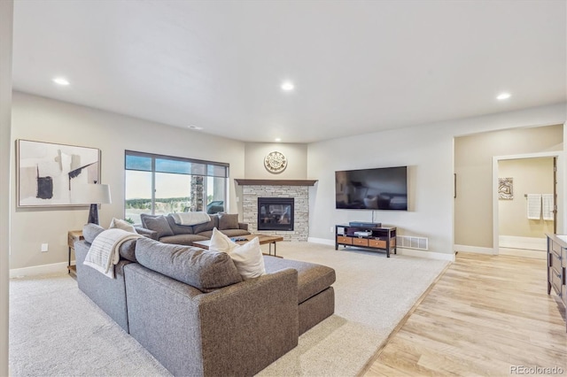 living room with baseboards, visible vents, a fireplace, recessed lighting, and light wood-style floors