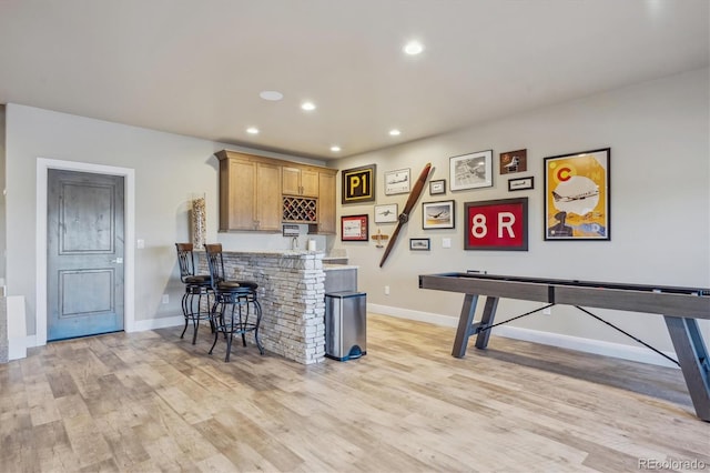 rec room with recessed lighting, light wood-type flooring, bar area, and baseboards