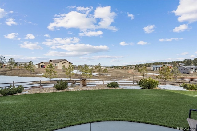 view of yard with a water view and fence