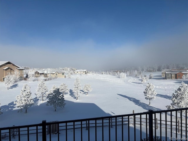 yard layered in snow featuring a residential view