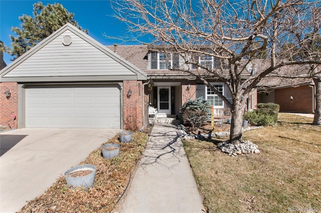 traditional-style house featuring a garage, a front yard, brick siding, and driveway