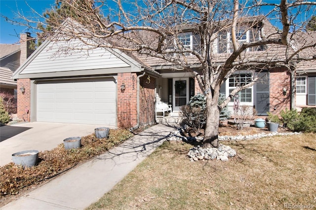 view of front of home featuring an attached garage, concrete driveway, and brick siding