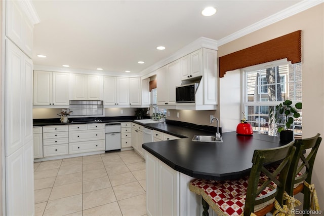 kitchen featuring dark countertops, a sink, and a peninsula