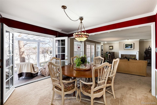 dining room featuring plenty of natural light, a high end fireplace, and crown molding