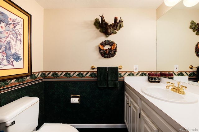 bathroom with toilet, wainscoting, and vanity