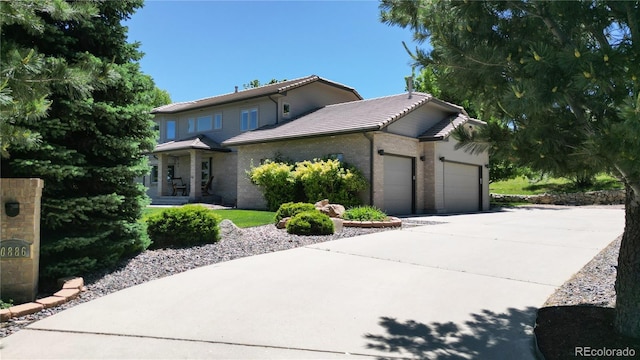 10886 Pheasant Run, Littleton, CO 80125 - view of front of property with a tiled roof, a garage, concrete driveway, and brick siding