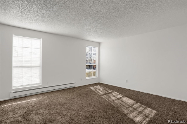 spare room with a textured ceiling, carpet flooring, and a baseboard heating unit