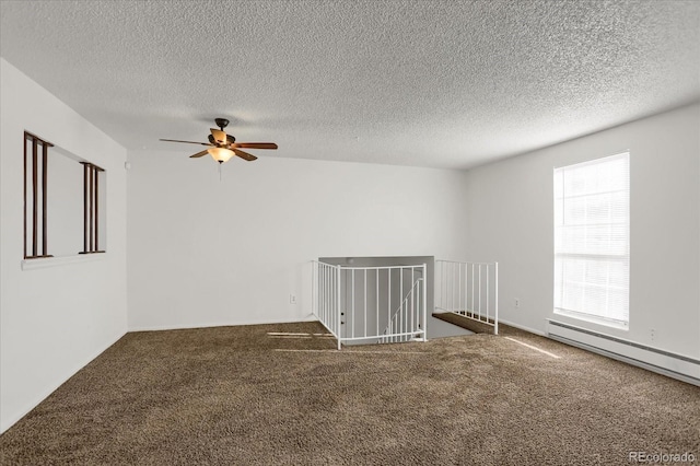 unfurnished room with a baseboard heating unit, a textured ceiling, ceiling fan, and carpet