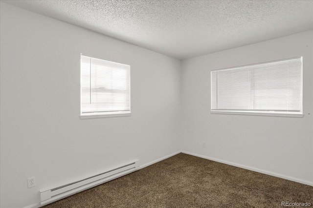 carpeted empty room with baseboard heating and a textured ceiling