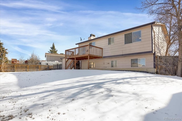 snow covered house featuring a deck