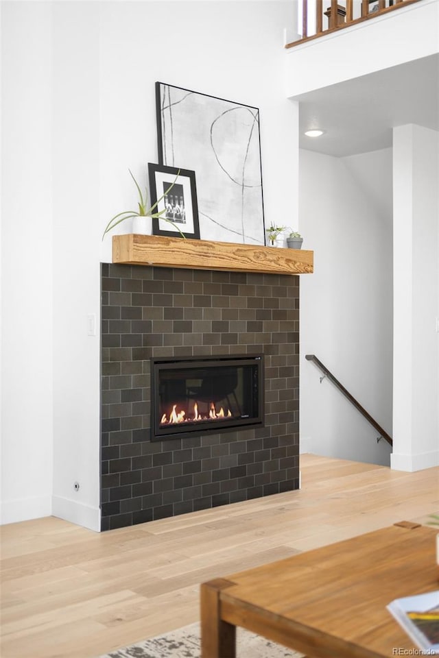 room details with a brick fireplace, baseboards, and wood finished floors