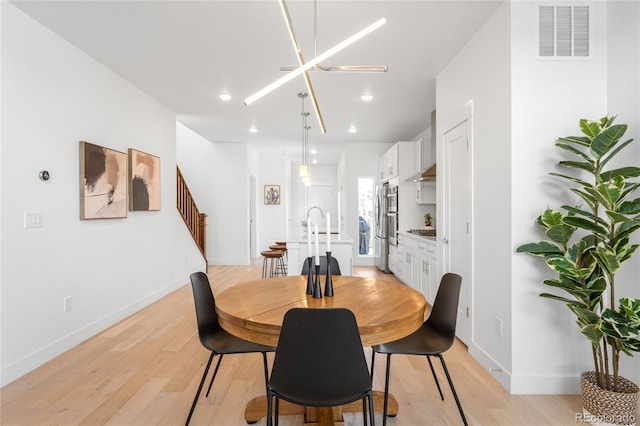 dining room featuring light wood-style flooring, recessed lighting, baseboards, and visible vents