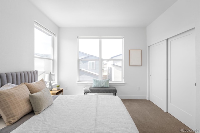 bedroom with dark colored carpet and baseboards