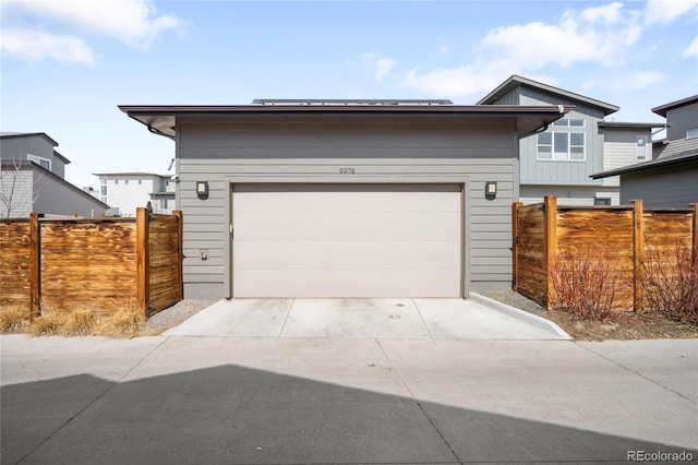 view of front facade with concrete driveway and fence